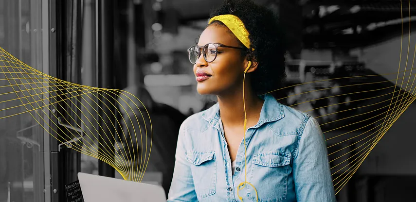 Woman wearing a yellow headband, glasses, with earbuds working