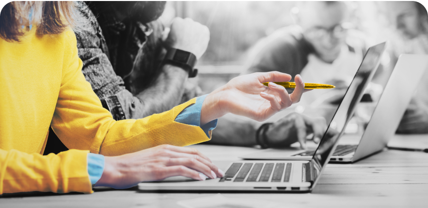 Close up of the hand of a worker pointing a pen at a creative project displayed on their laptop screen