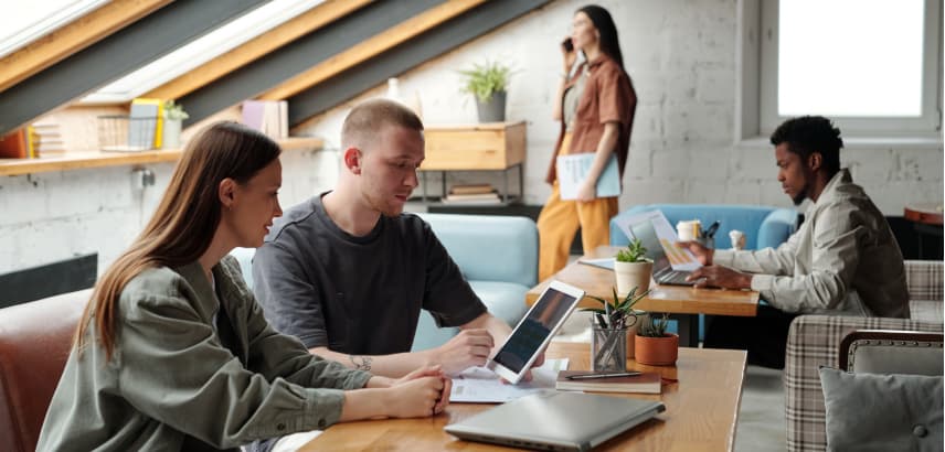 Male and female coworkers with a tablet working on a presentation